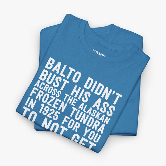 Folded heather blue t-shirt showing the Balto didn't bust his ass pro-vaccine graphic in white block letters
