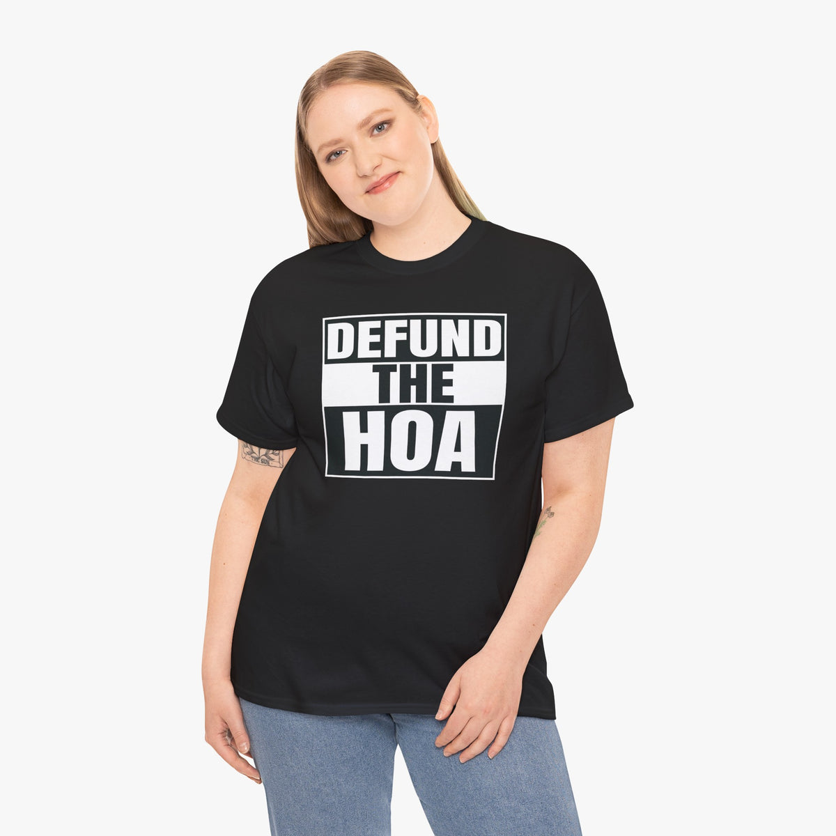 Woman wearing a black DEFUND THE HOA t-shirt with jeans, smiling and tilting her head